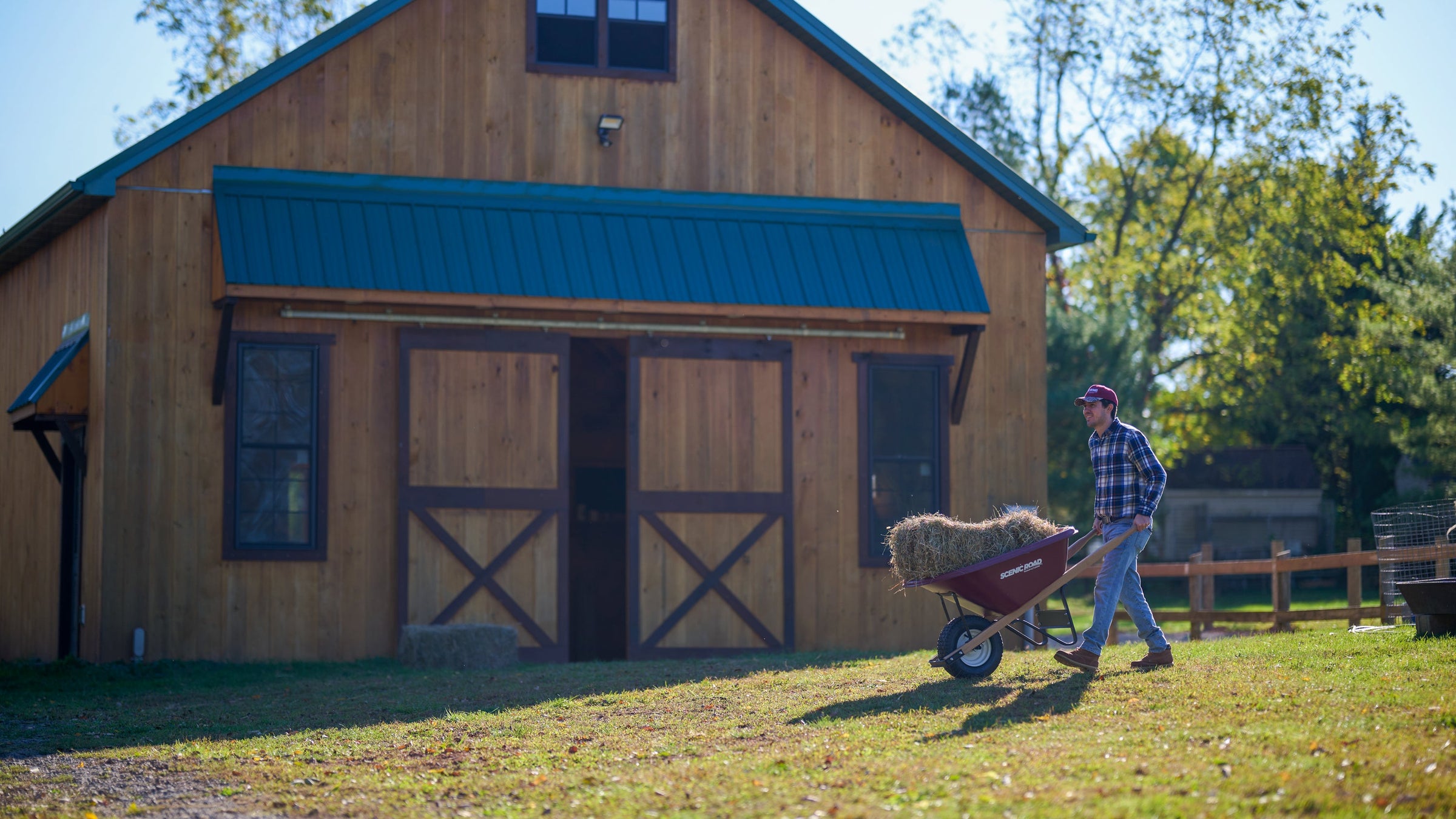 Wheelbarrow with hay bale at barn