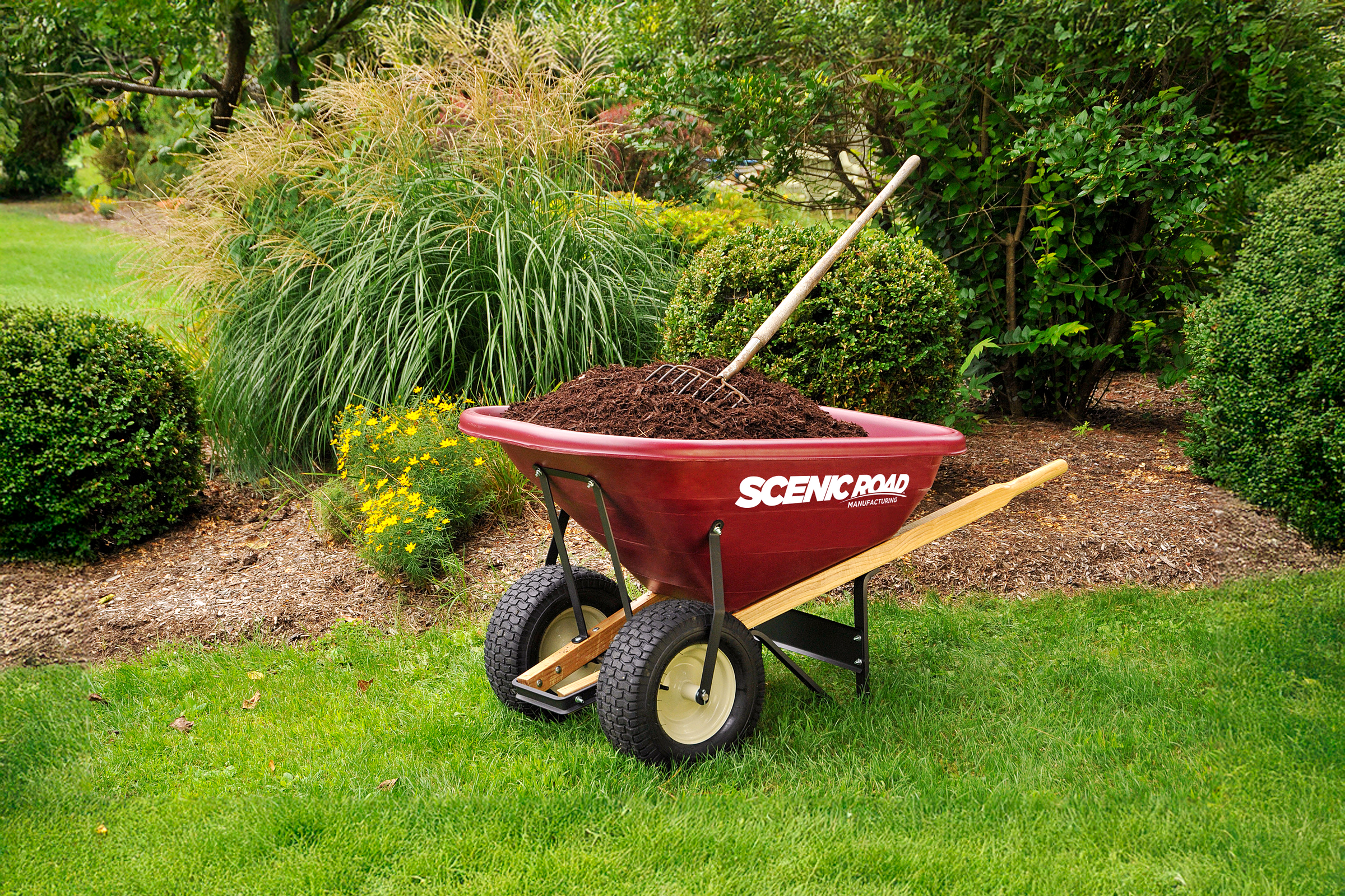 Scenic Road wheelbarrow with mulch in garden setting